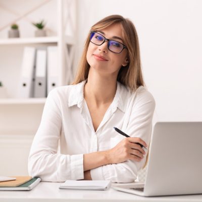 confident-businesswoman-smiling-at-camera-sitting-NHJXPND.jpg